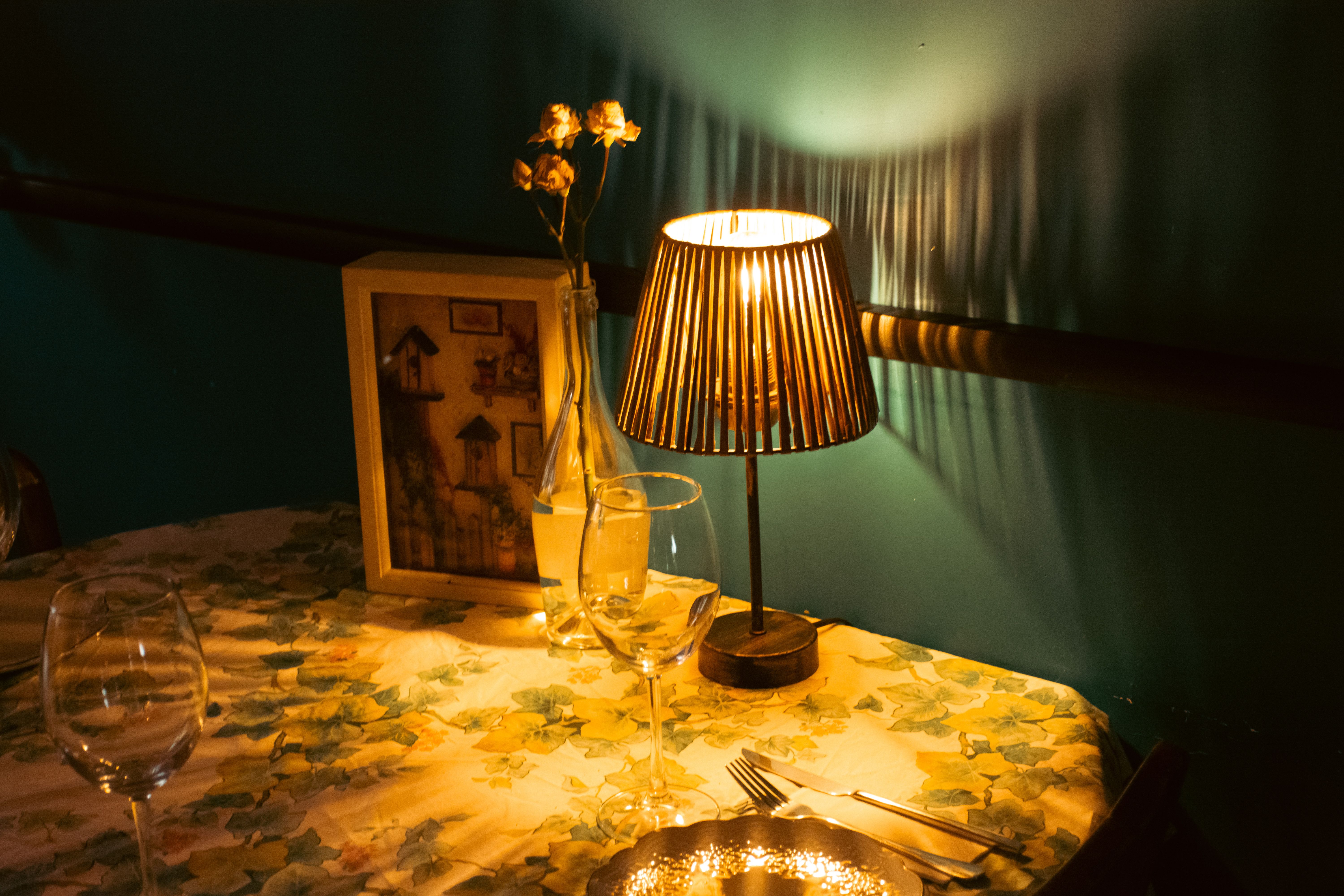 Warm and inviting table setup with a lamp casting soft light, perfect for intimate dining.
