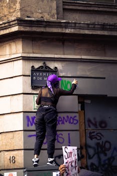 A woman protests in front of a marked wall during a demonstration in Mexico City.