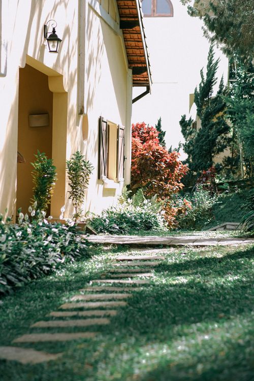 Free A picturesque garden pathway with sunlight filtering through trees in Đà Lạt, Vietnam. Stock Photo