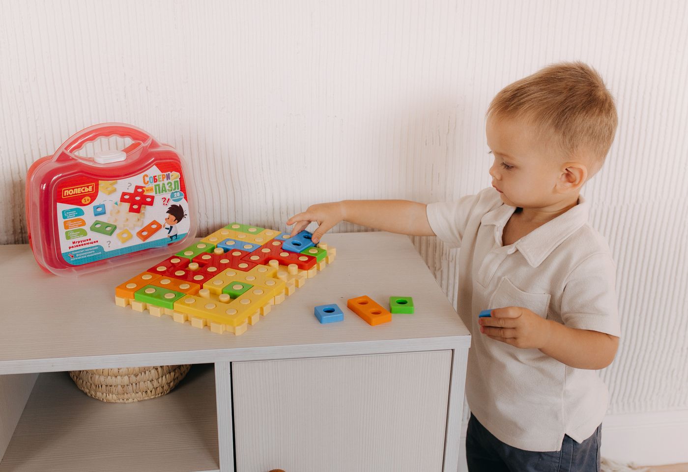 Young child exploring a colorful educational toy set during indoor learning play