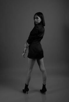 Striking black and white portrait of a woman in a stylish outfit posing with confidence.