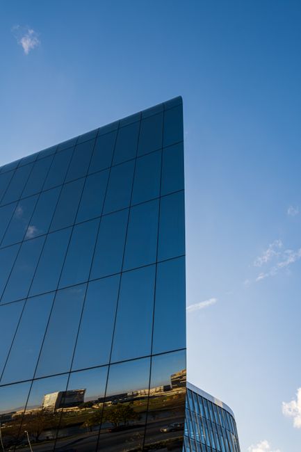A sleek glass skyscraper reflecting the sky in Vilnius, Lithuania. Captures modern architecture.