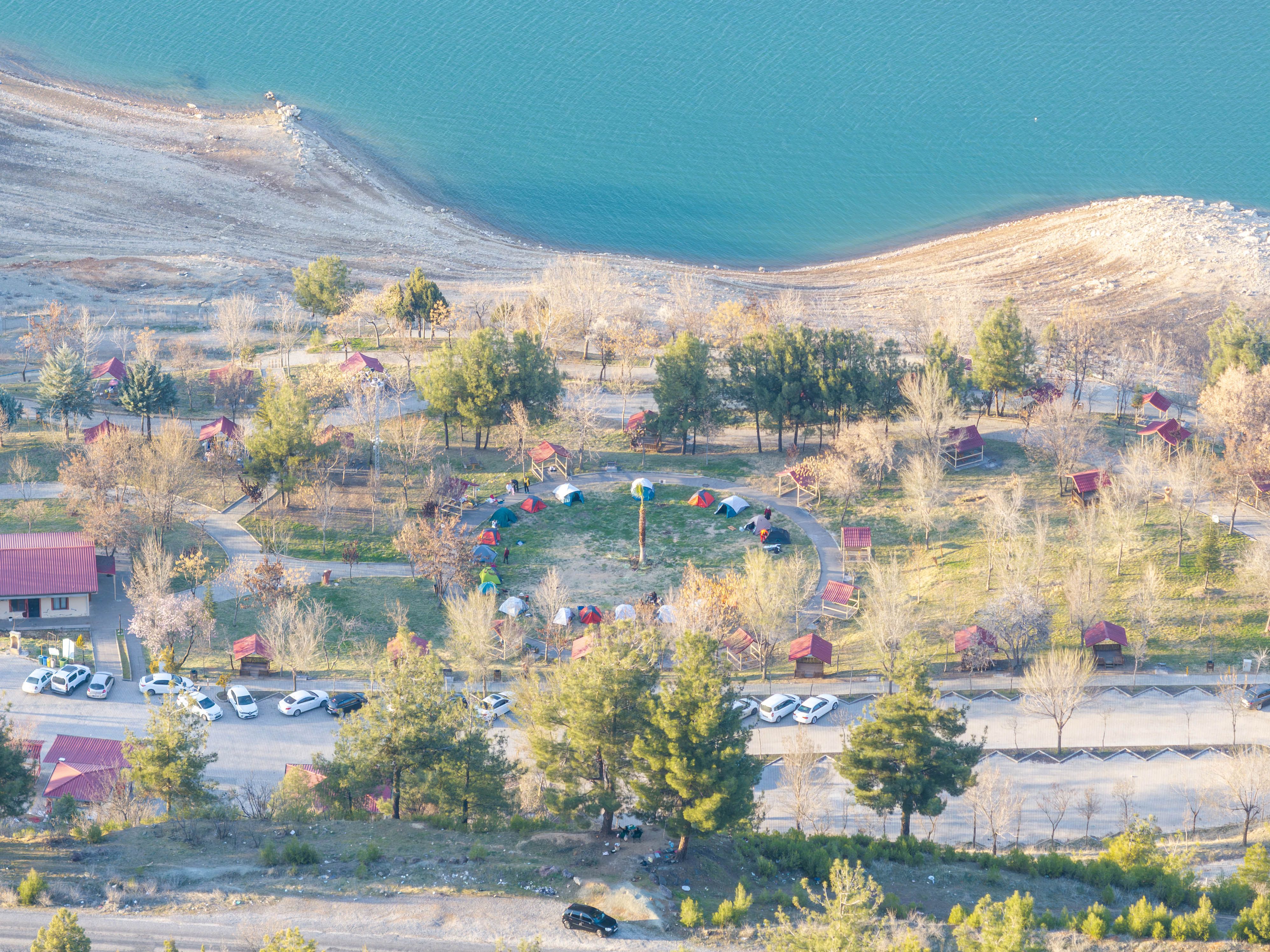 Aerial view of a campground with colorful tents by a serene lake in Kahramanmaraş, Türkiye.