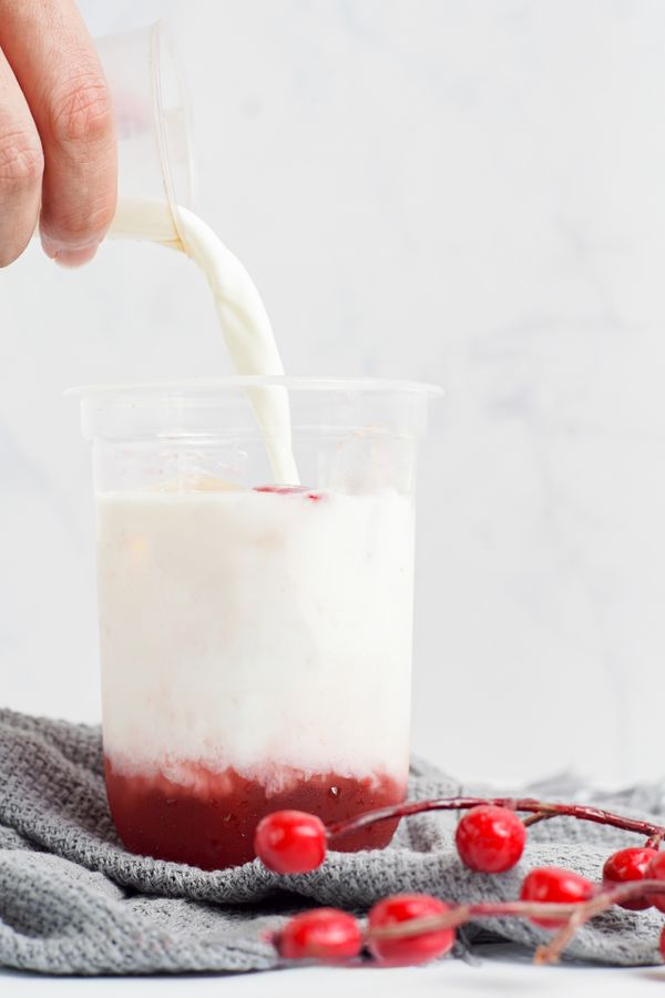 Milk poured into a clear cup with strawberry jam and fresh berries — photo by Miff Ibra on Pexels