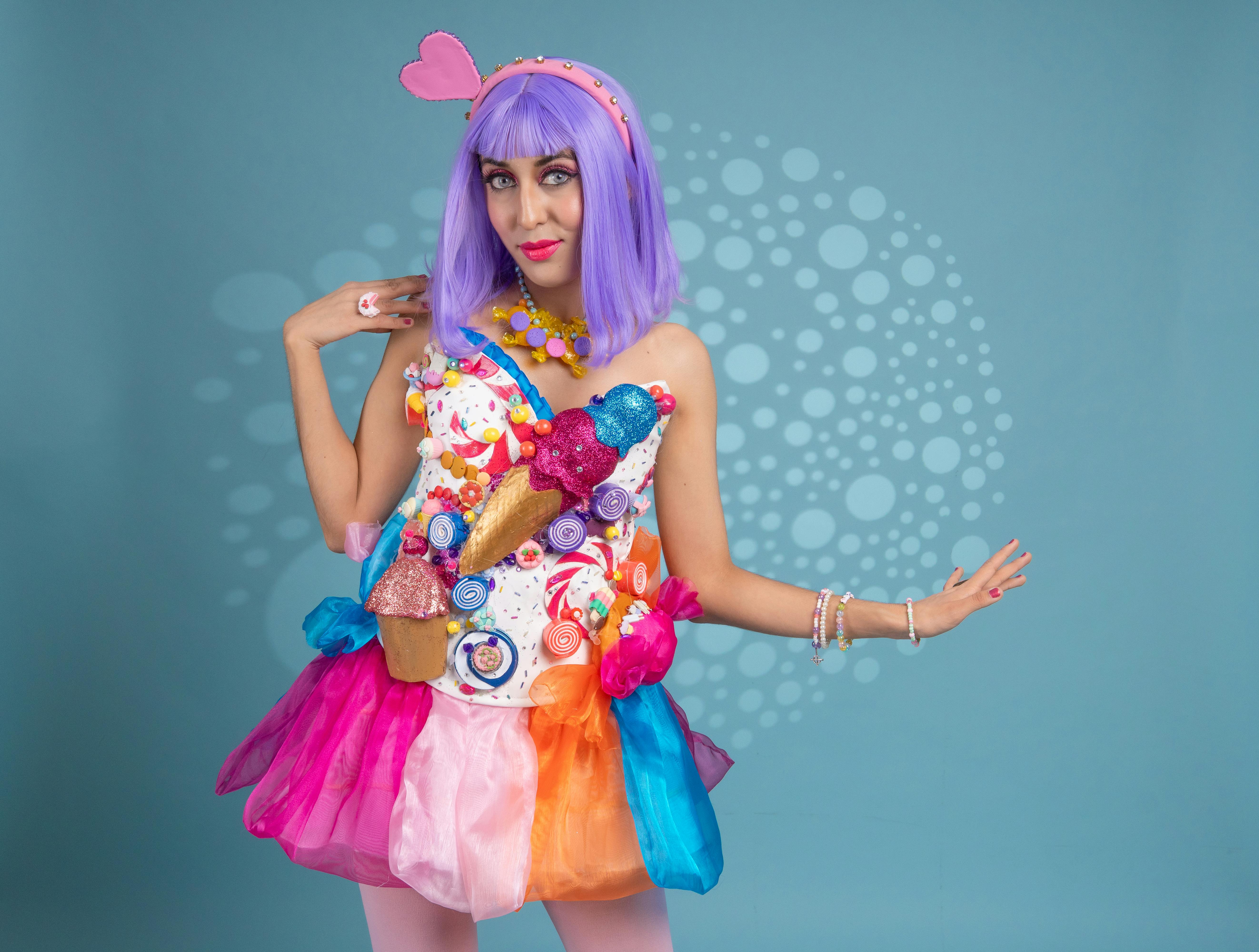 ingyenes Színes művészi cosplay nő cukorka témájú jelmezben, kék háttérrel. Stockfotó