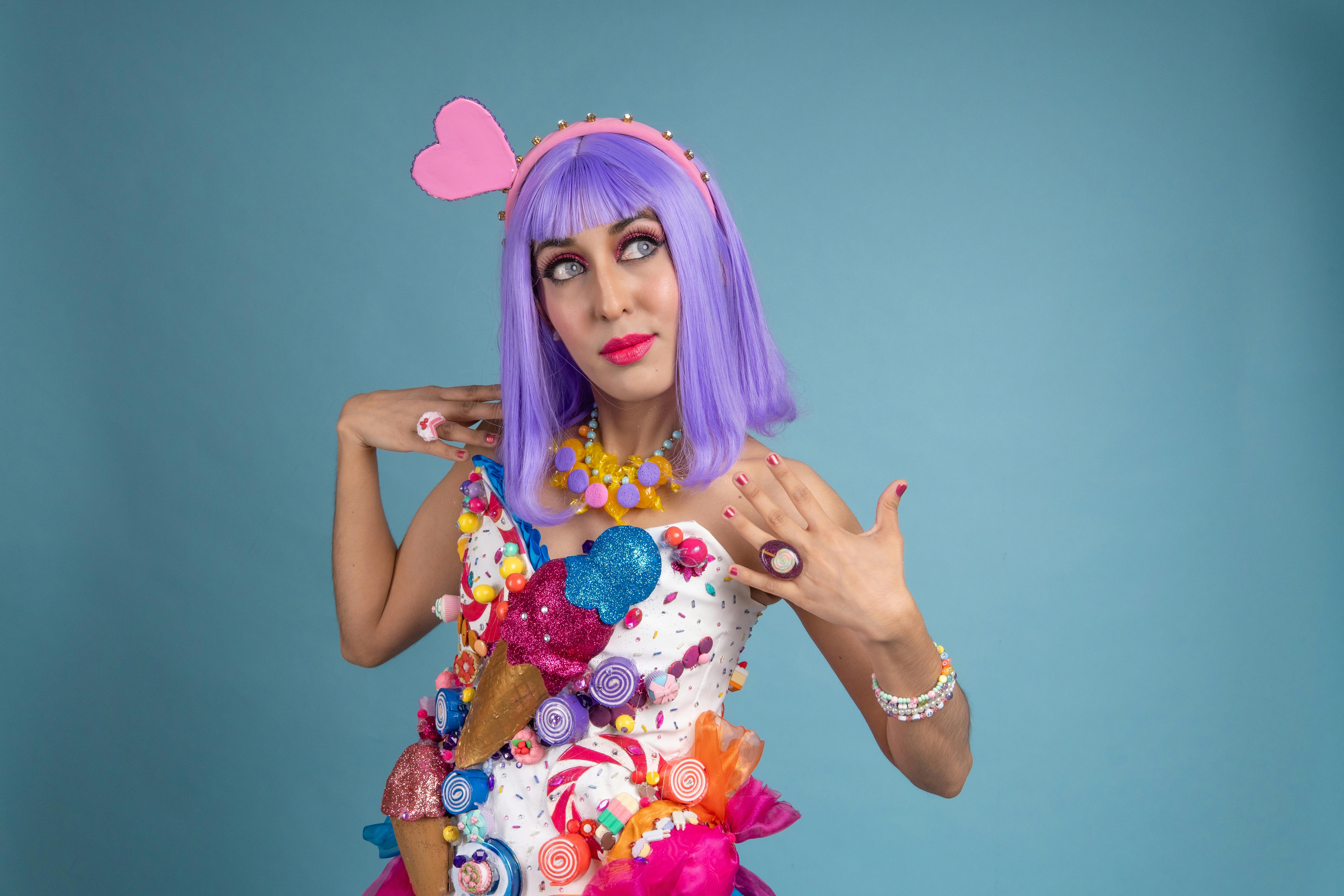 ingyenes Színes cosplay portré egy nőről cukorka témájú öltözékben, kék háttérrel. Stockfotó