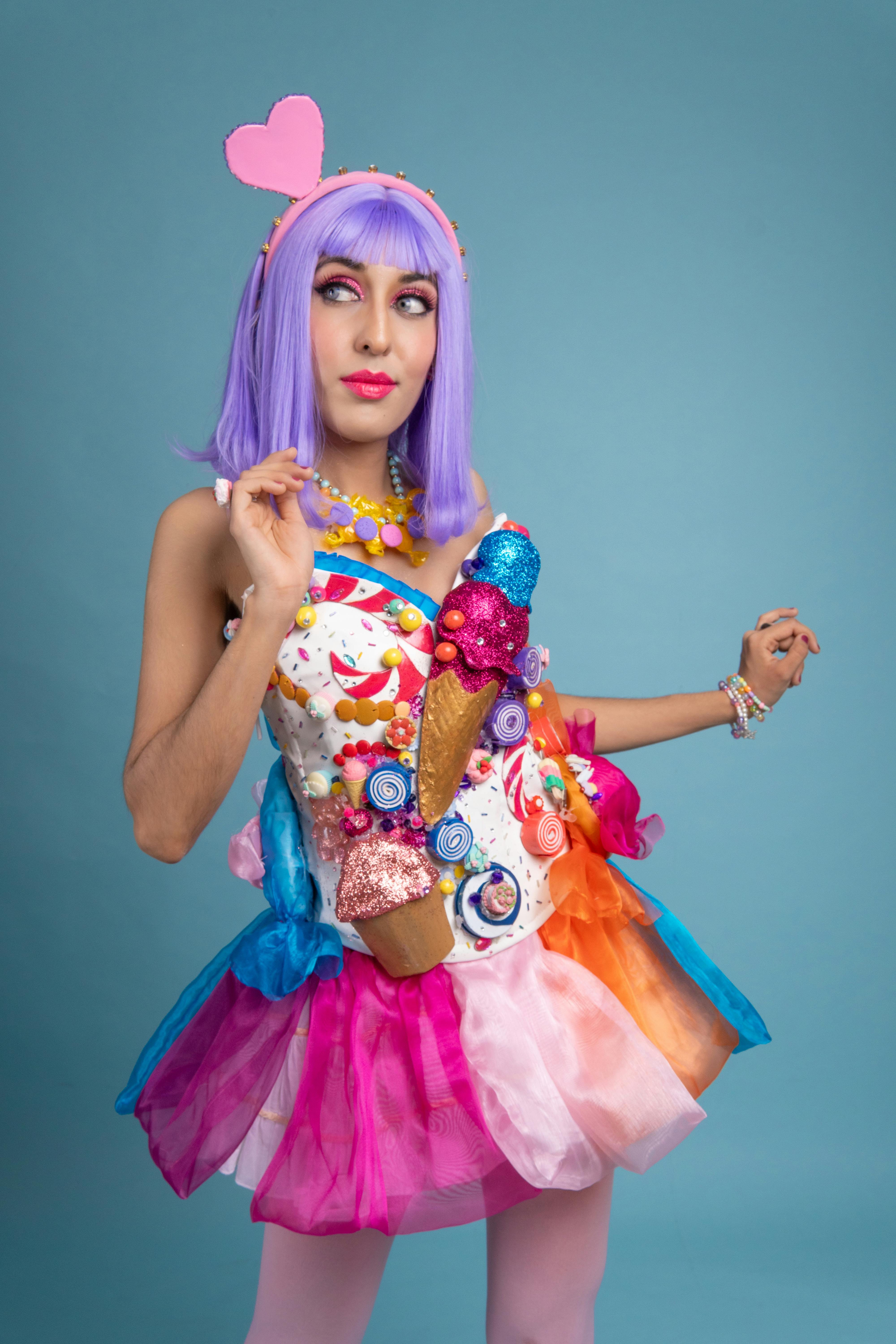 ingyenes Színes cosplay jelmez lila hajjal és cukorka témájú öltözékkel kék alapon. Stockfotó