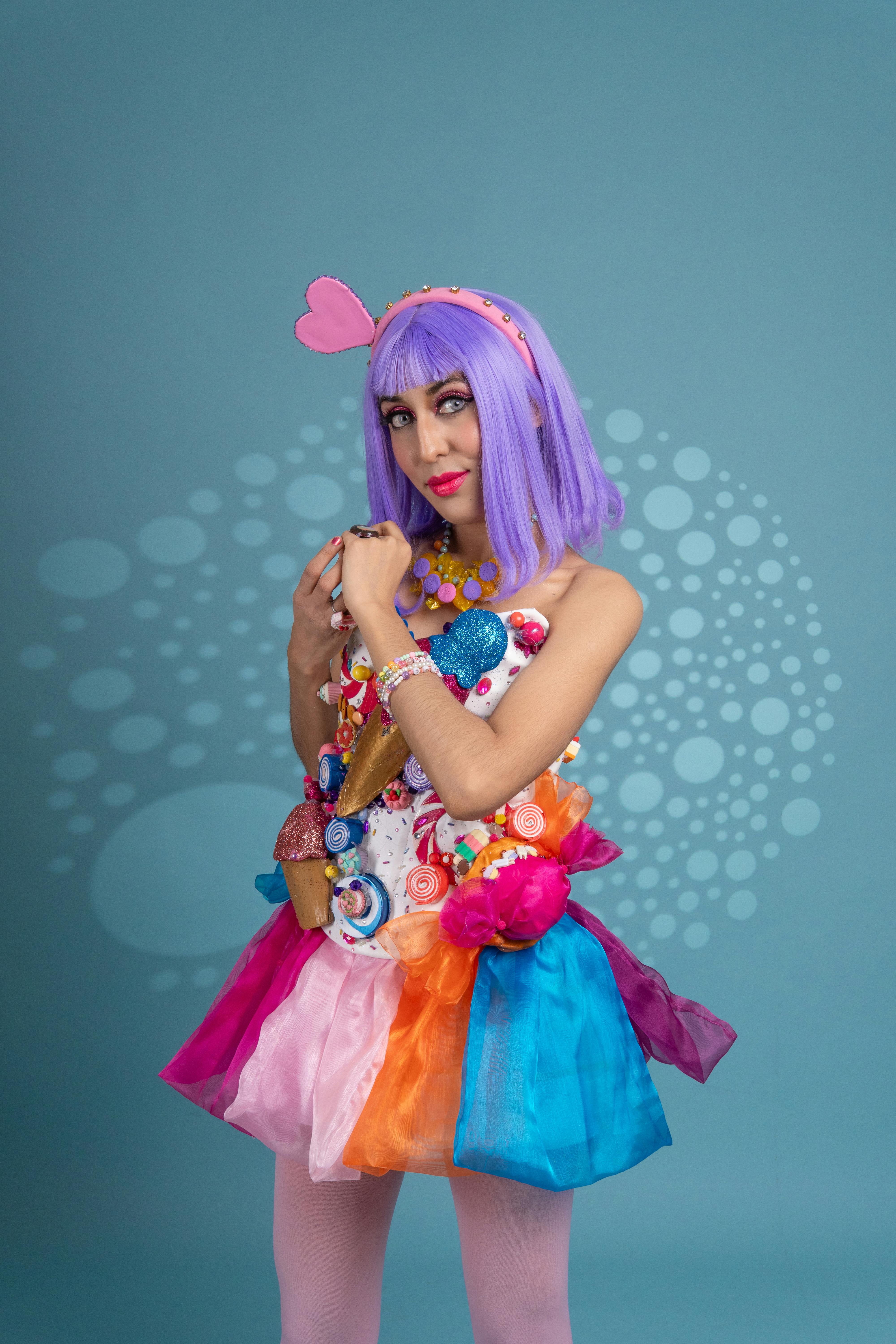 ingyenes Élénk cosplay lila hajjal és színes öltözékkel a kék háttér előtt. Stockfotó