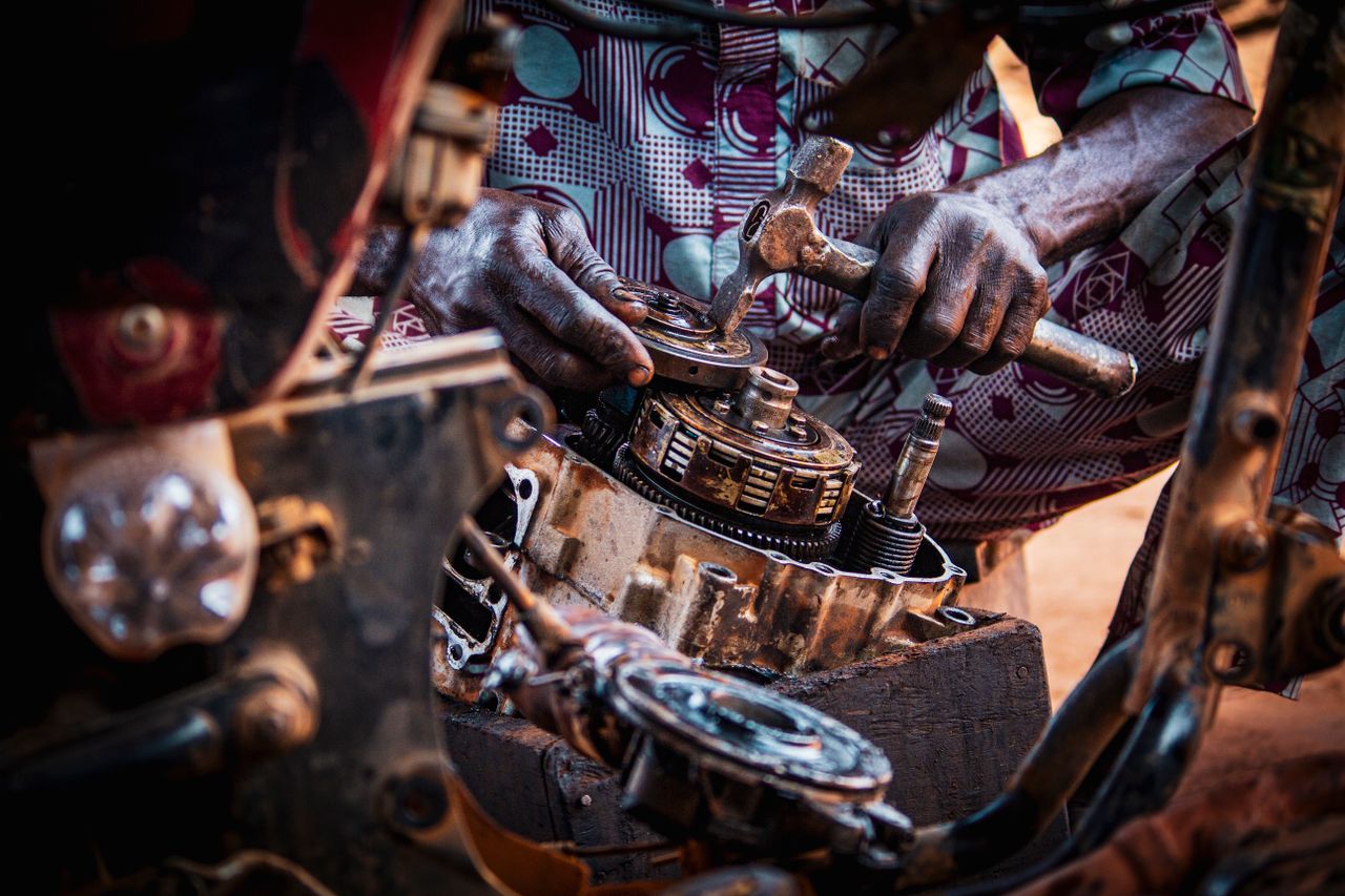 mechanic focused on assembling motorcycle engine parts in a workshop