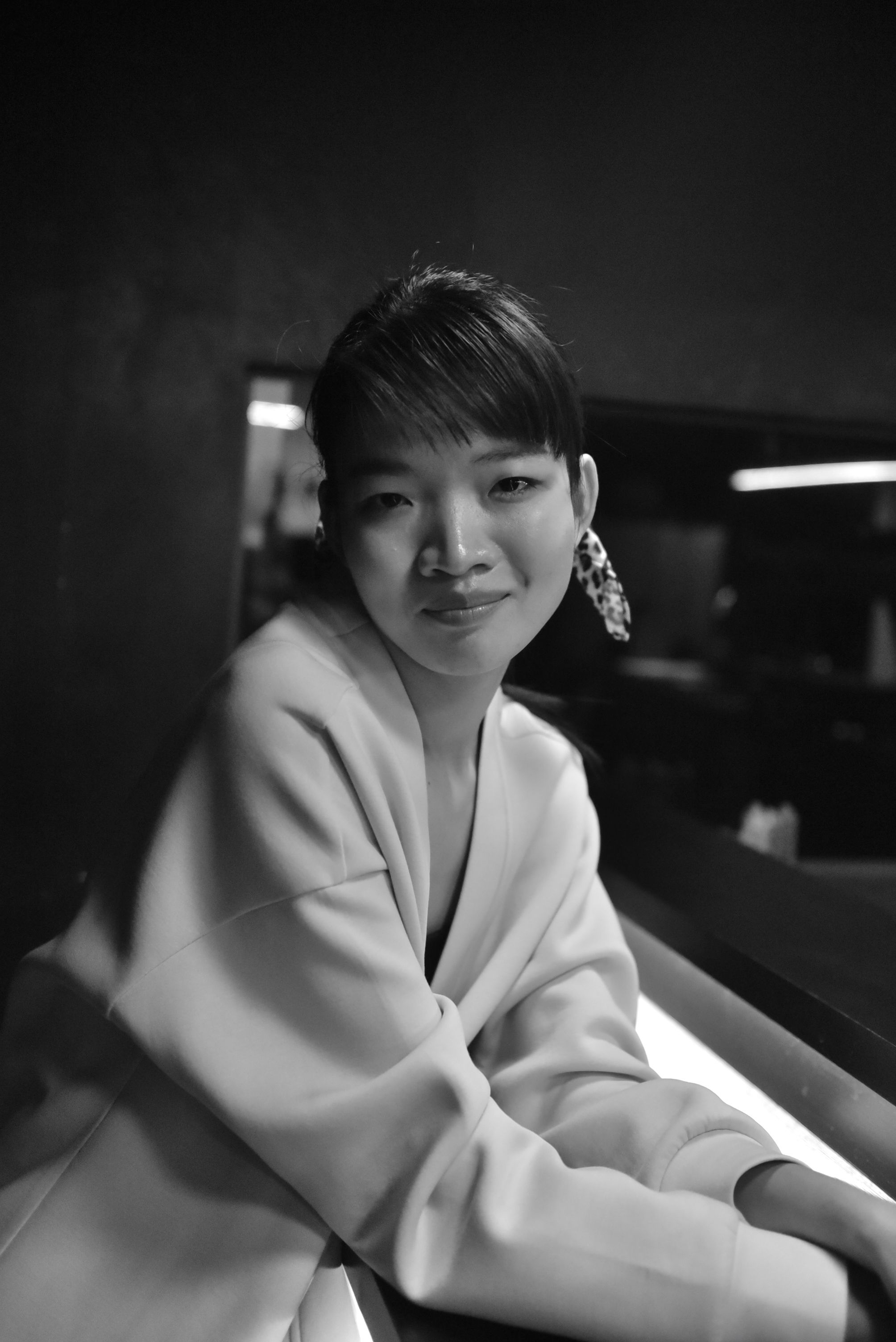 Charming black and white portrait of a woman in a cozy bar setting.
