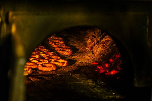 Free Close-up of freshly baked bread rings inside a wood-fired oven. Stock Photo