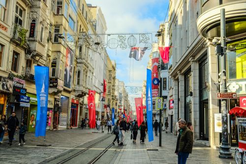 Free Bustling Istiklal Street with Turkish flags, shops, and pedestrians in Istanbul. Stock Photo