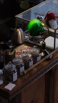 A cozy coffee shop setup with tea jars, electric kettle, and retro lamp.