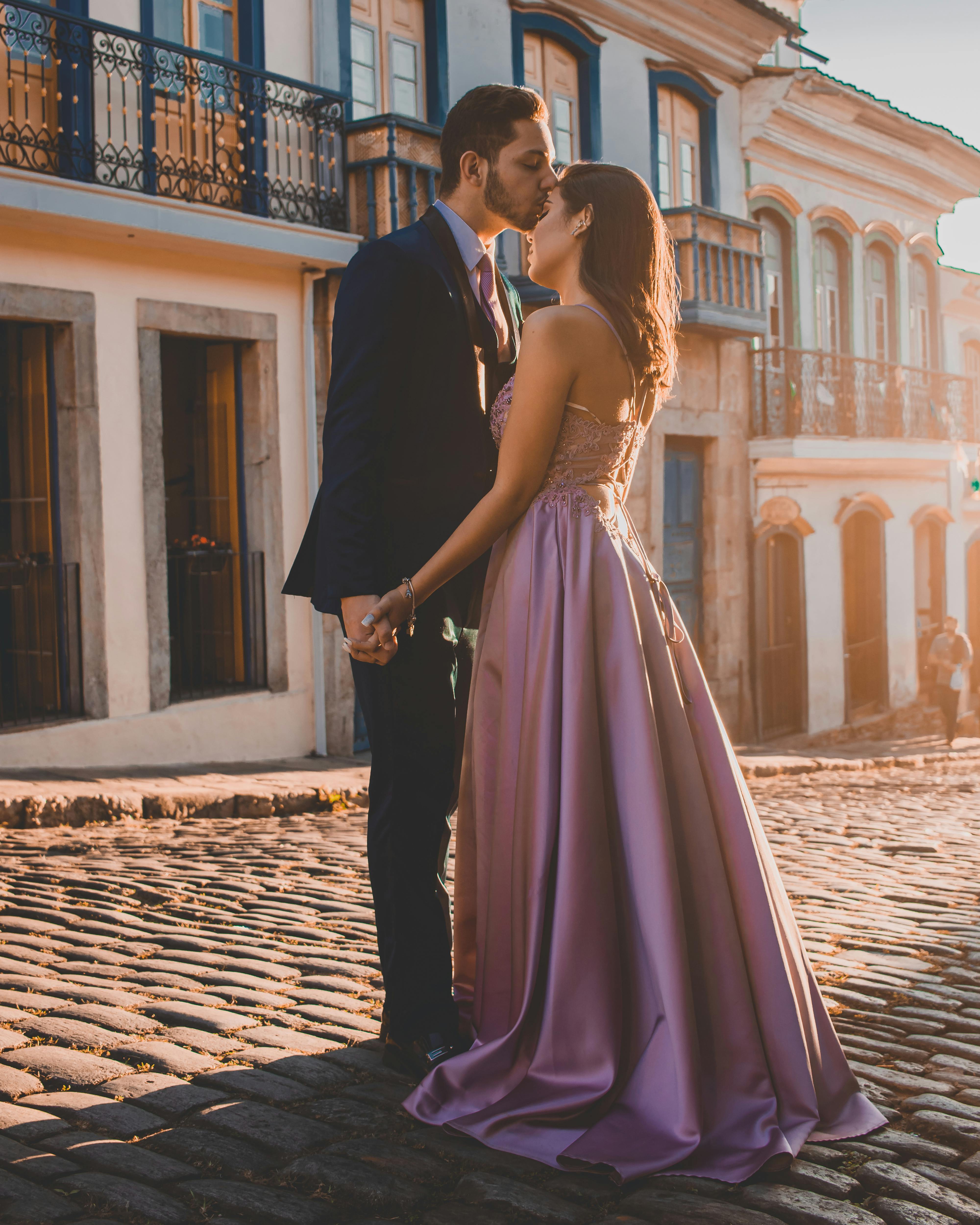 一对情侣在鹅卵石街道上拥抱亲吻，浪漫而亲密