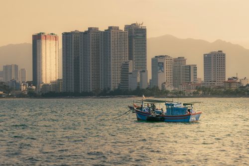 Free Explore the serene coastal skyline of Nha Trang with boats floating in the calm sea. Stock Photo