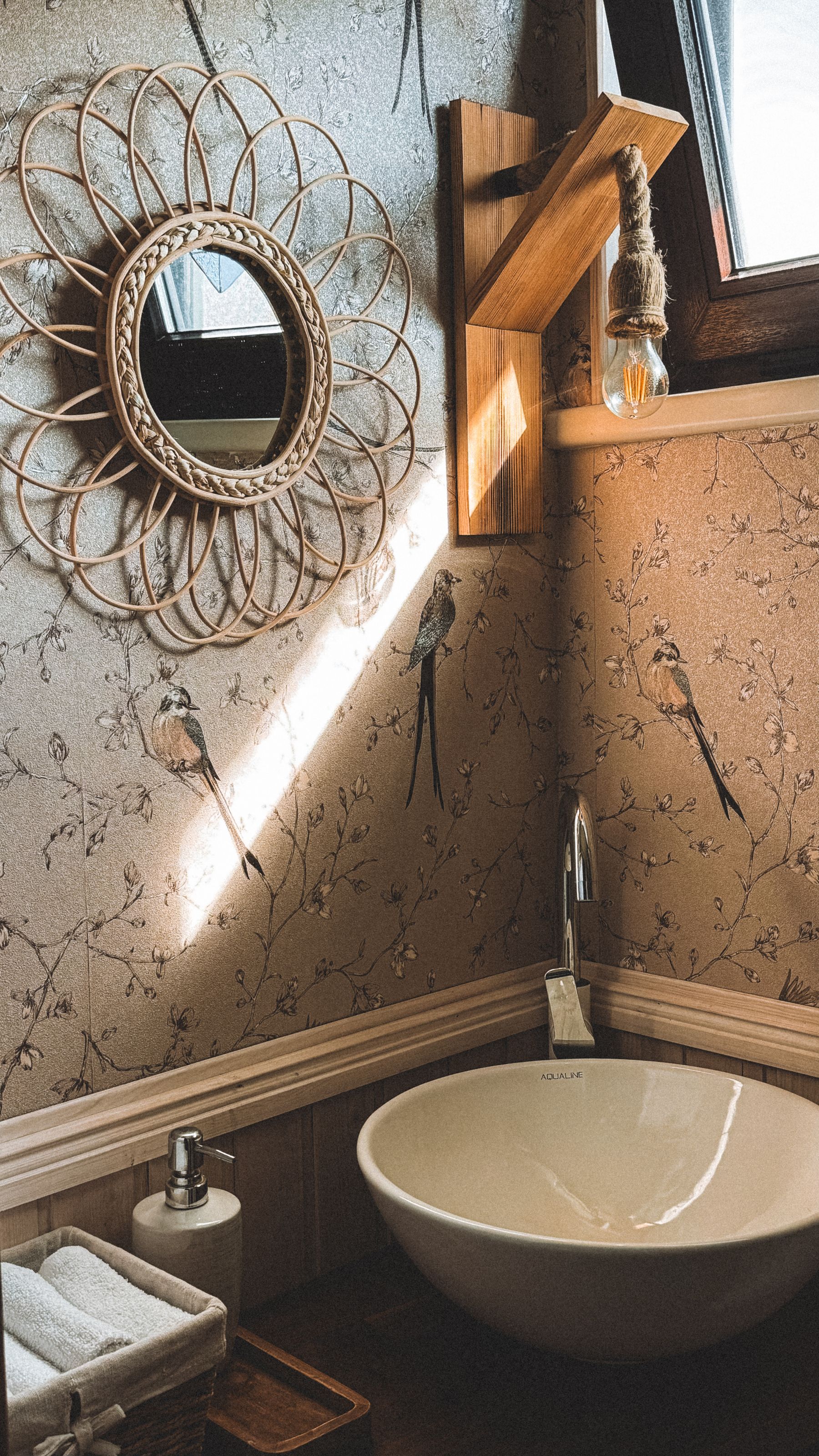 Bathroom vanity with woven mirror and neutral surrounding surfaces