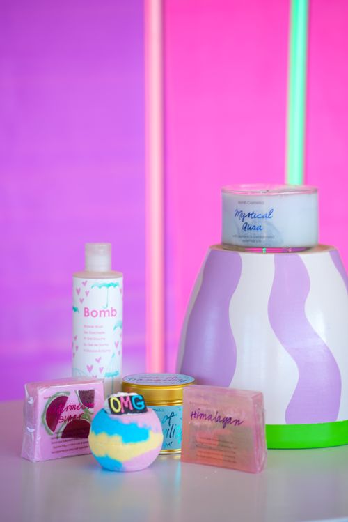 Free Colorful display of skincare products and candles with a bright neon backdrop. Stock Photo
