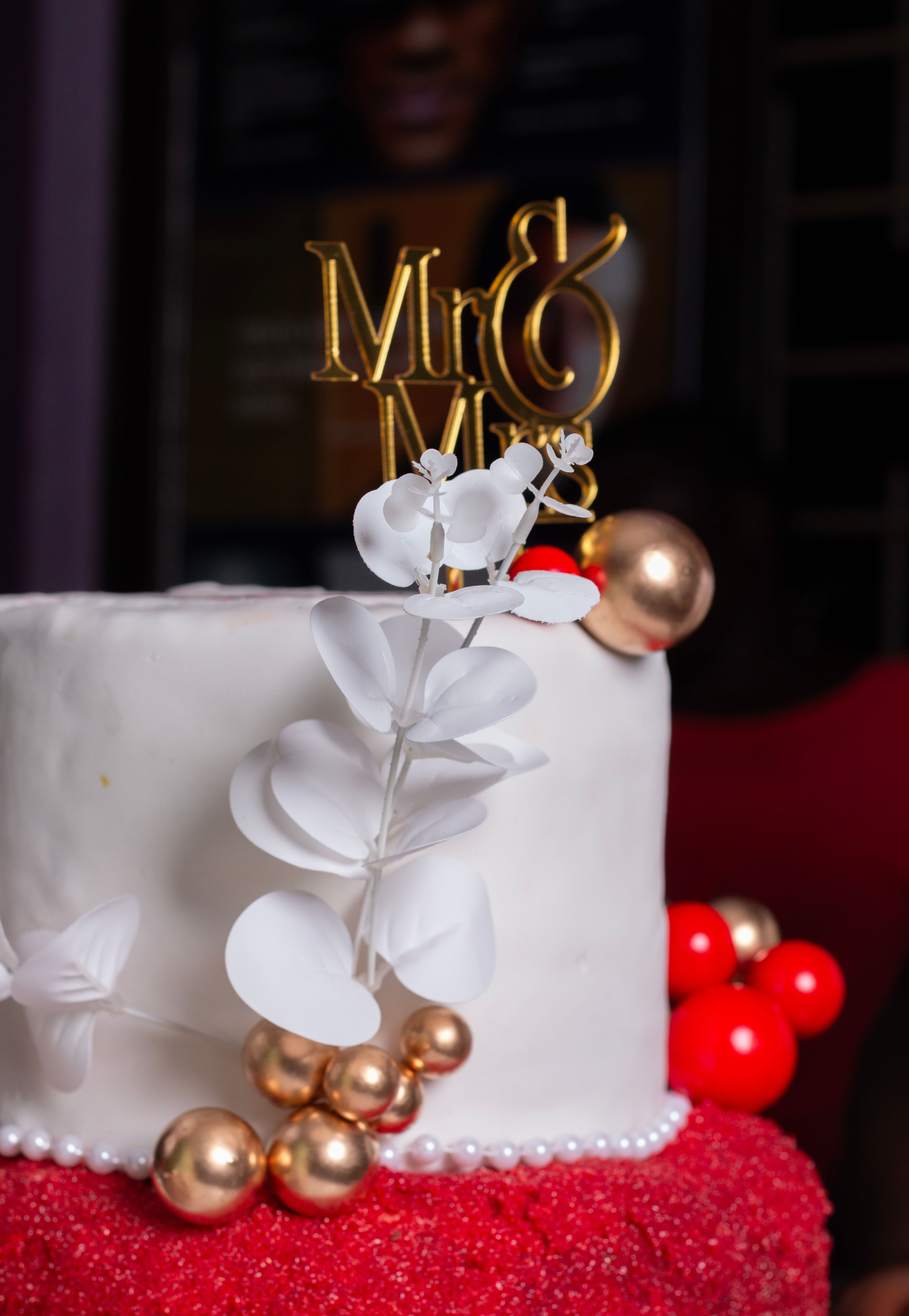Close-up of a wedding cake featuring 'Mr & Mrs' topper and floral decor.