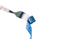 Creative dieting concept with fork and tape measure
