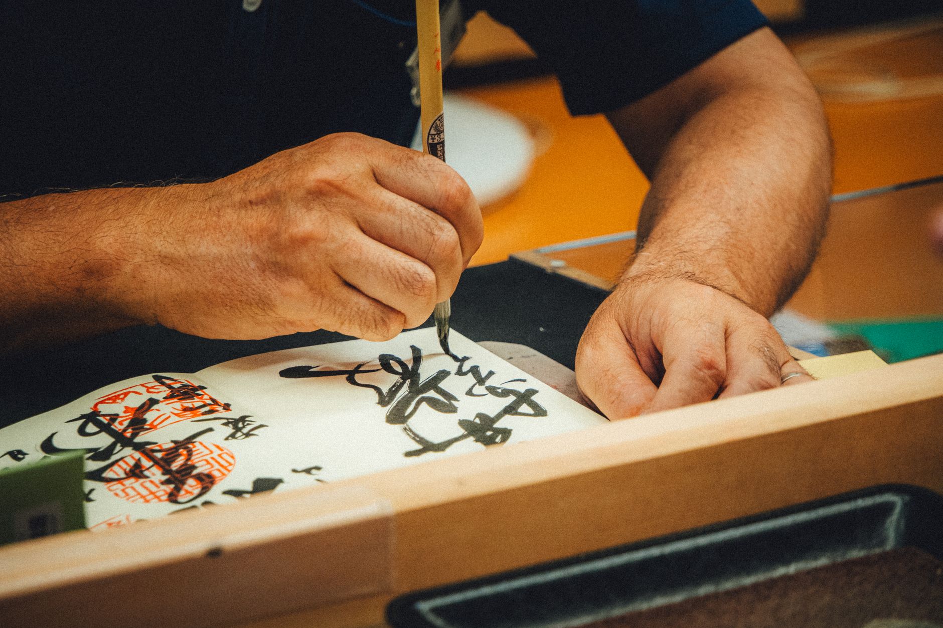 A close-up of an artist skillfully creating Japanese calligraphy with a brush.