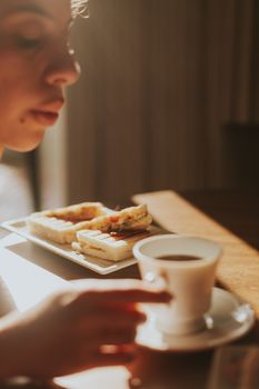 A cozy morning scene with coffee and sandwiches inviting relaxation.