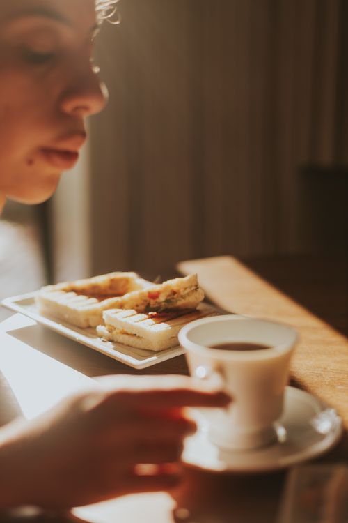Free A cozy morning scene with coffee and sandwiches inviting relaxation. Stock Photo