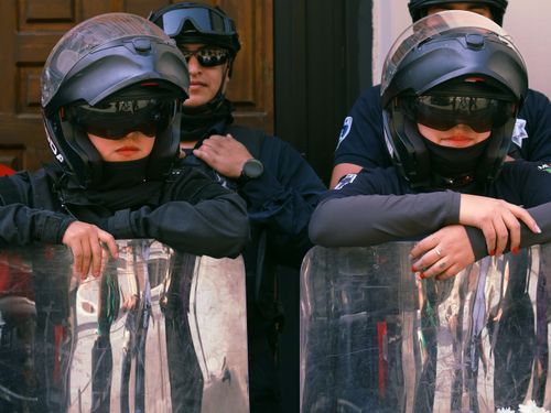 Free Group of police officers in full riot gear standing on duty outdoors. Stock Photo
