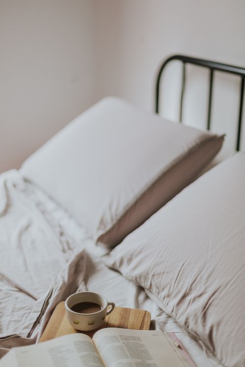 Free A serene morning setup with coffee and book on a bed, perfect for relaxation. Stock Photo