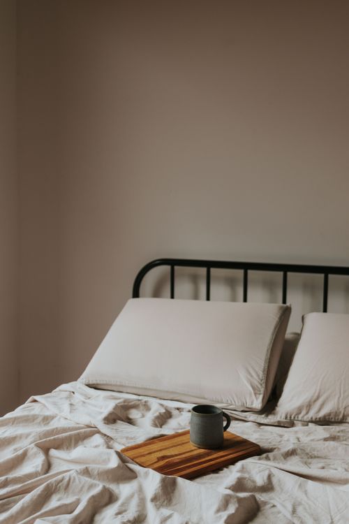 Free A minimalist morning scene with coffee mug on a bed, perfect for cozy routines. Stock Photo
