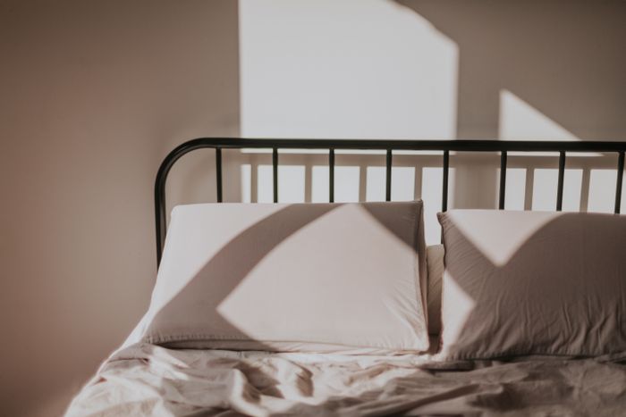 Morning light falling across a made bed — Letícia Alvares on Pexels