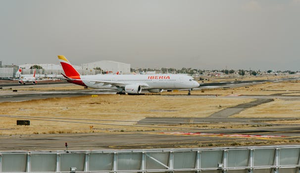 Iberia airplane preparing for takeoff at a busy airport runway on a clear day.