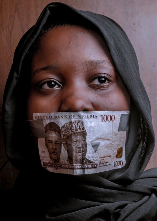 Free Woman Covering Her Mouth with 1000 Naira Note Stock Photo