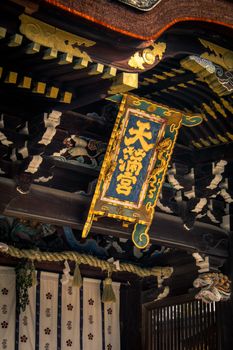 Detailed view of ornate wooden sign at a historic shrine in Kyoto, Japan.