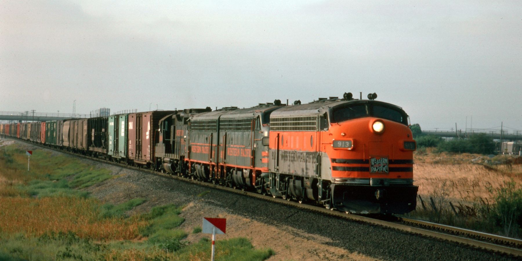 A vintage diesel locomotive freight train traveling through Milpitas countryside.