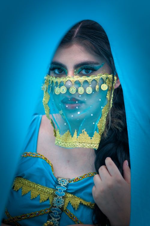 Free A captivating portrait of a woman wearing an ornate blue veil with gold details, emphasizing cultural beauty. Stock Photo