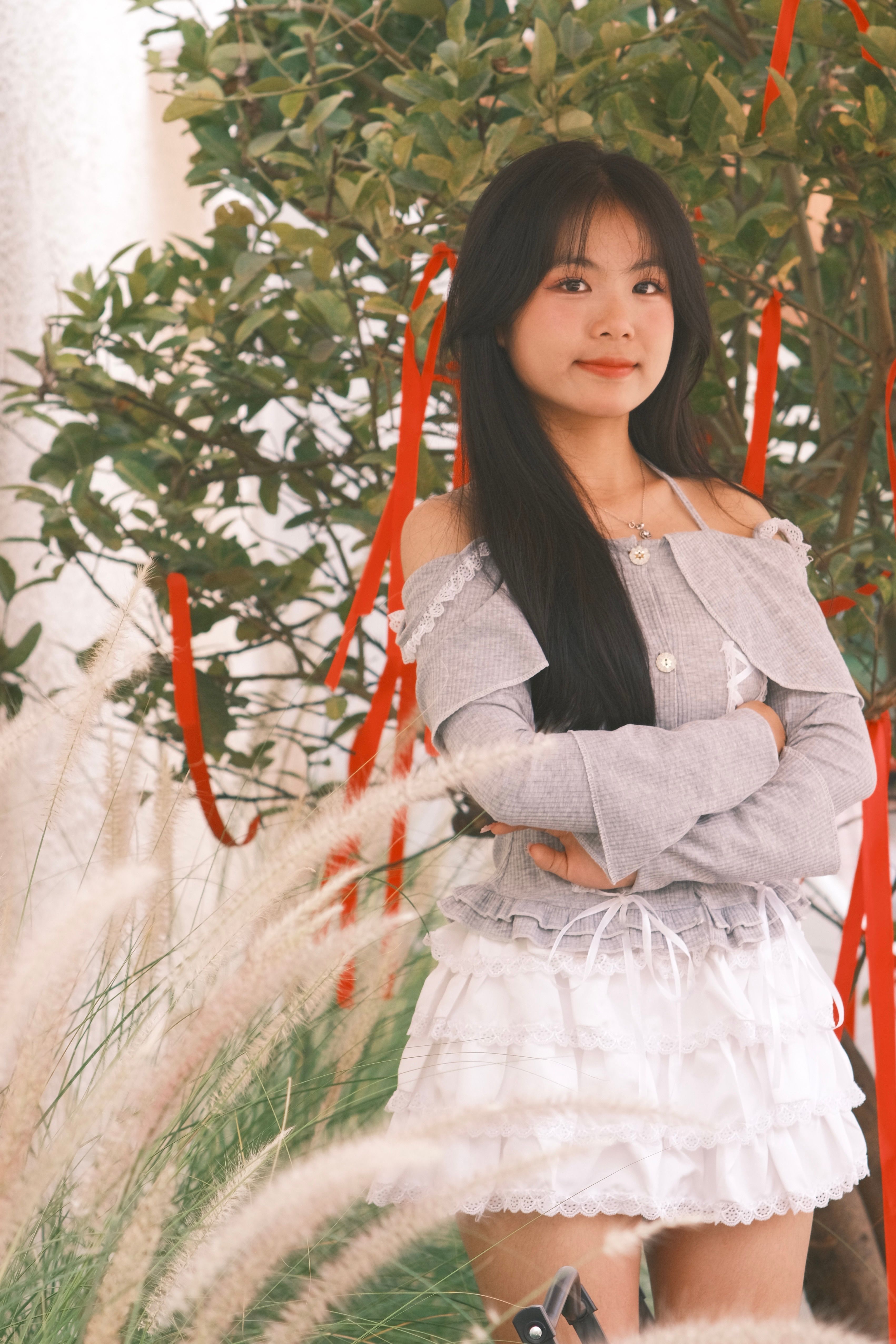 Young Woman Posing Outdoors with Greenery · Free Stock Photo