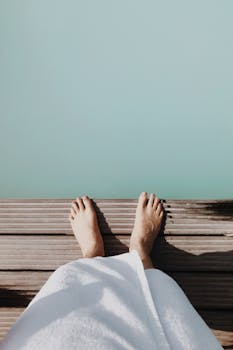 Person relaxing by a geothermal spa in Reykjavik, enjoying a serene view.