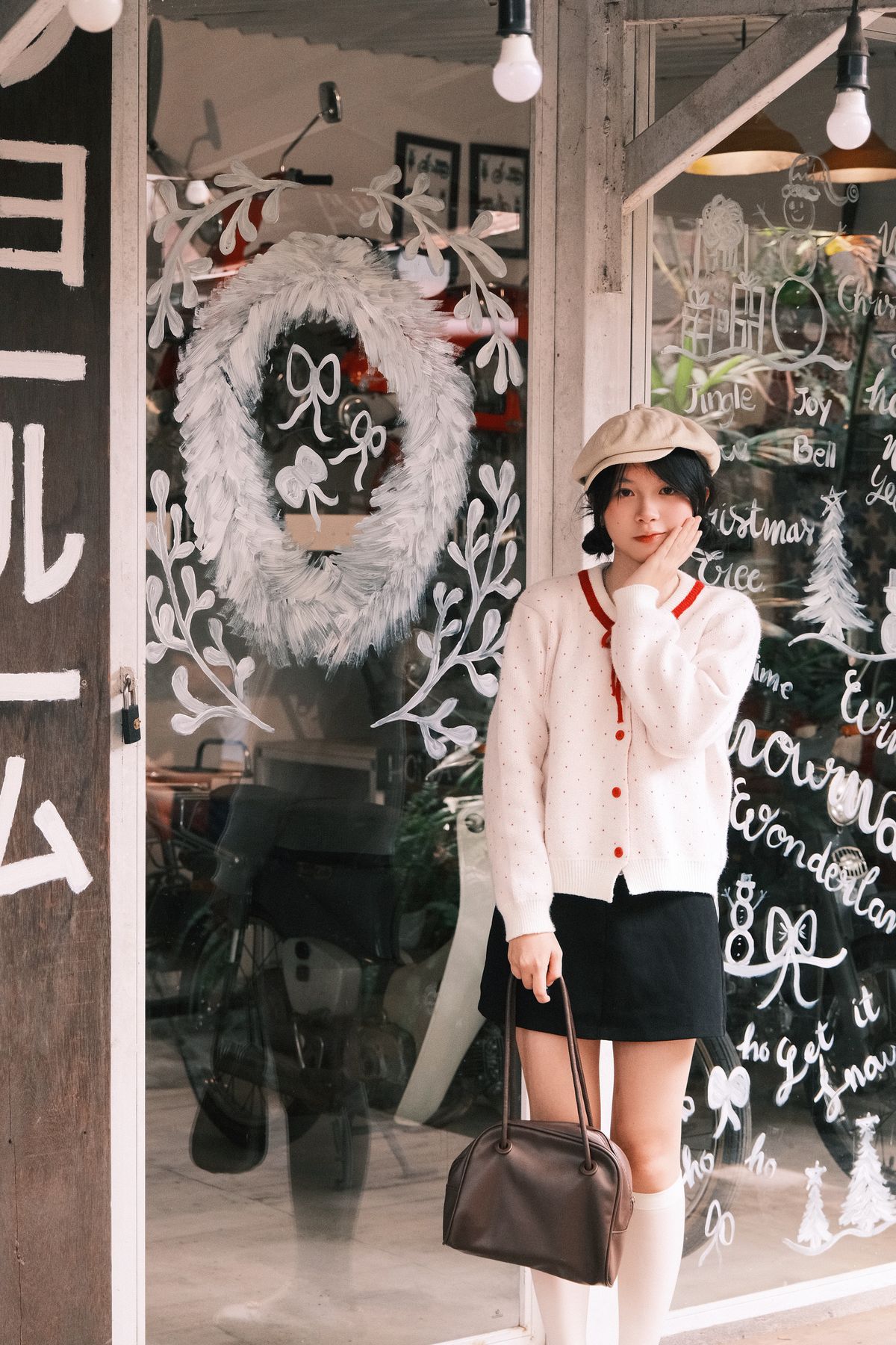 Korean woman in a winter knit cardigan and mini skirt outside a festive café — Korean winter casual outfit