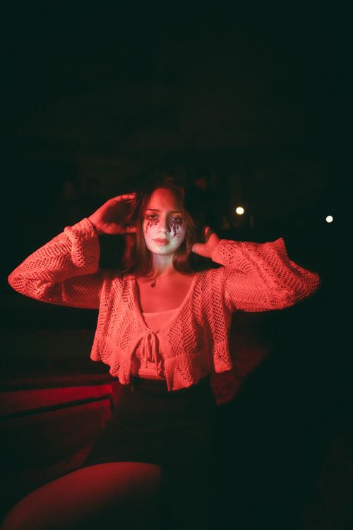Free A woman poses under dramatic and moody lighting in a captivating portrait. Stock Photo