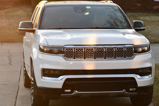 Close-up of a white SUV parked outdoors. Captured during sunset creating a warm glow.