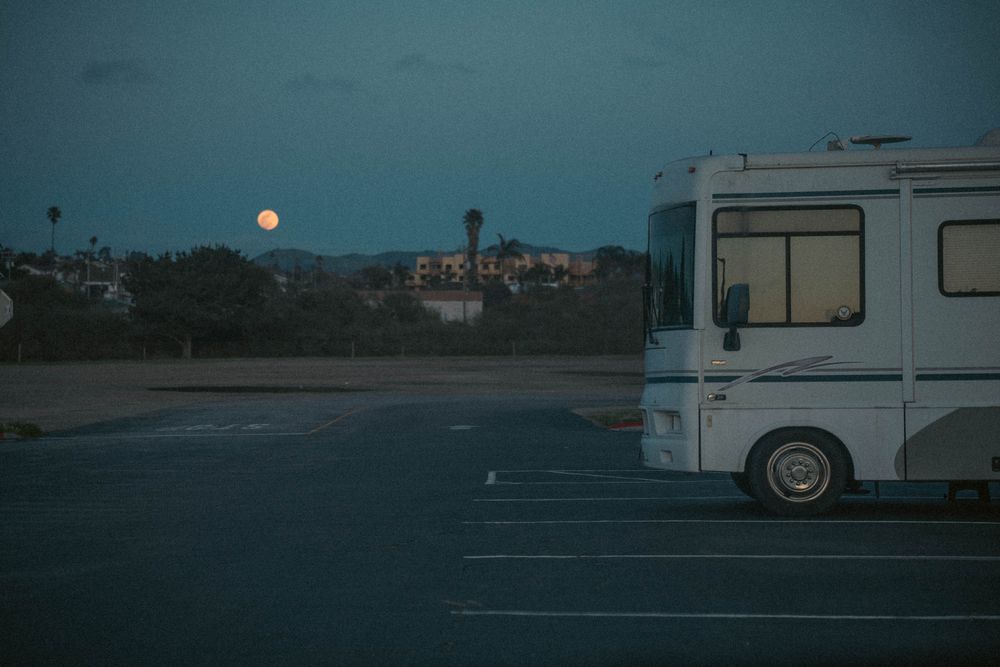 Coach at dusk beneath a rising full moon