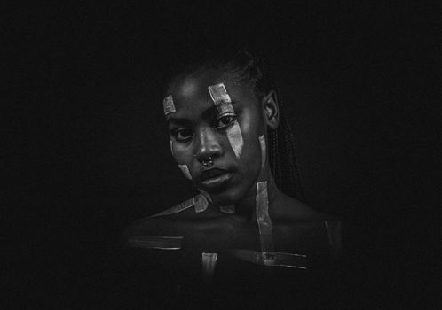 Black and white portrait of a woman with tape art accentuating her features.