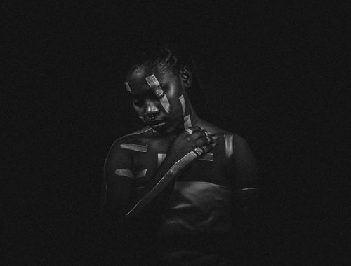 Free Abstract black and white portrait of a woman with reflective tape patches, conveying emotion and introspection. Stock Photo
