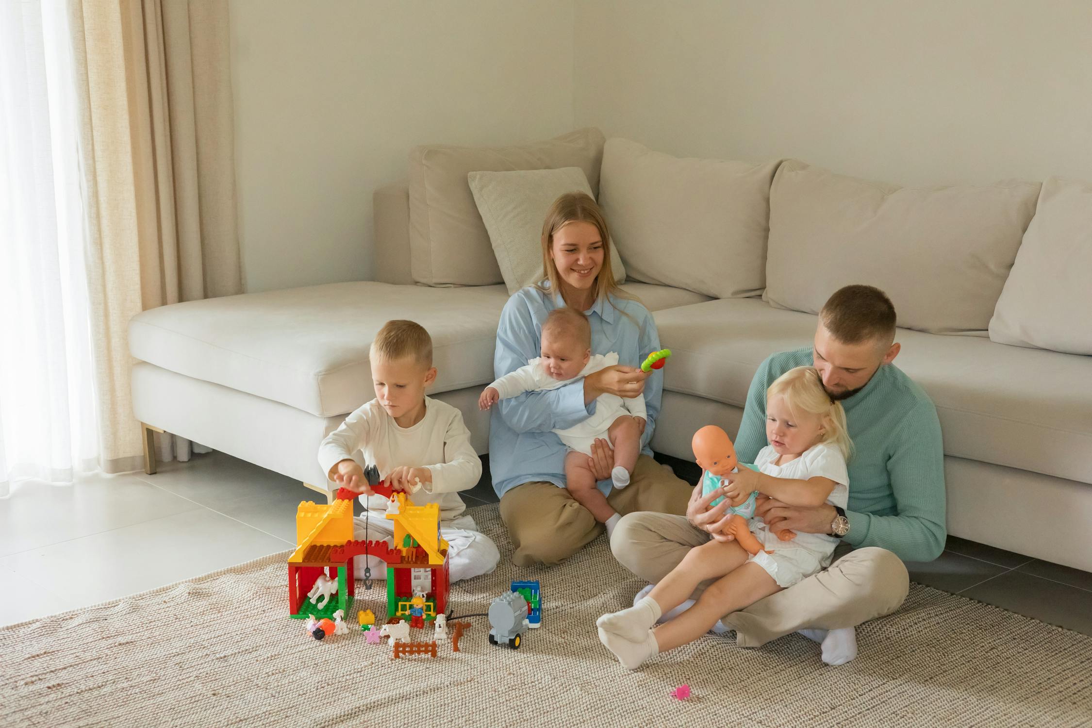 Happy family playing with toys in living room on parental leave