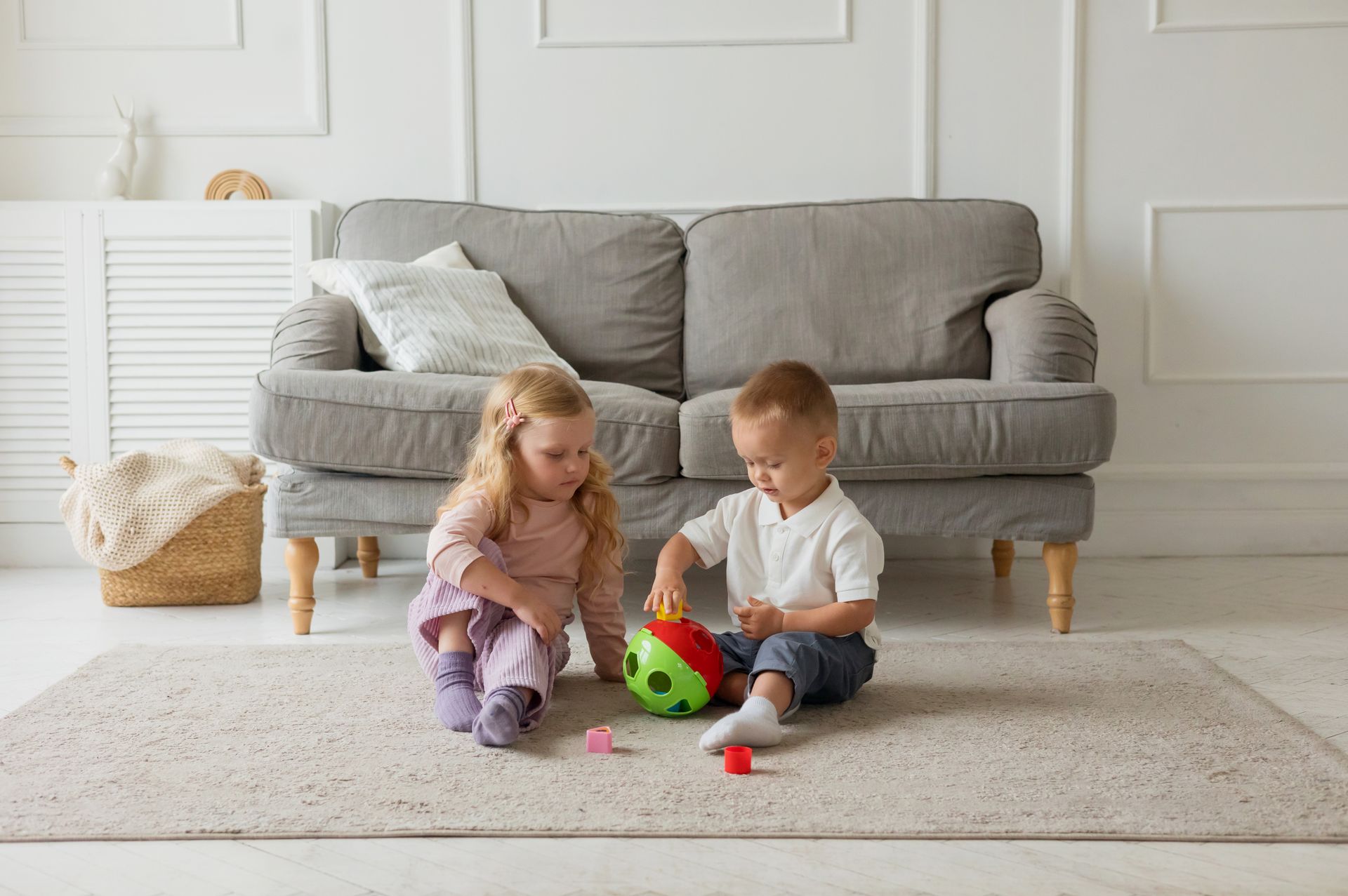 Two kids engaging with a toy in a cozy living room setting, fostering creativity.