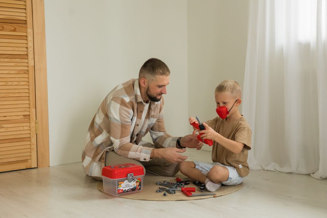 Father and son enjoying a creative toy toolbox activity together at home