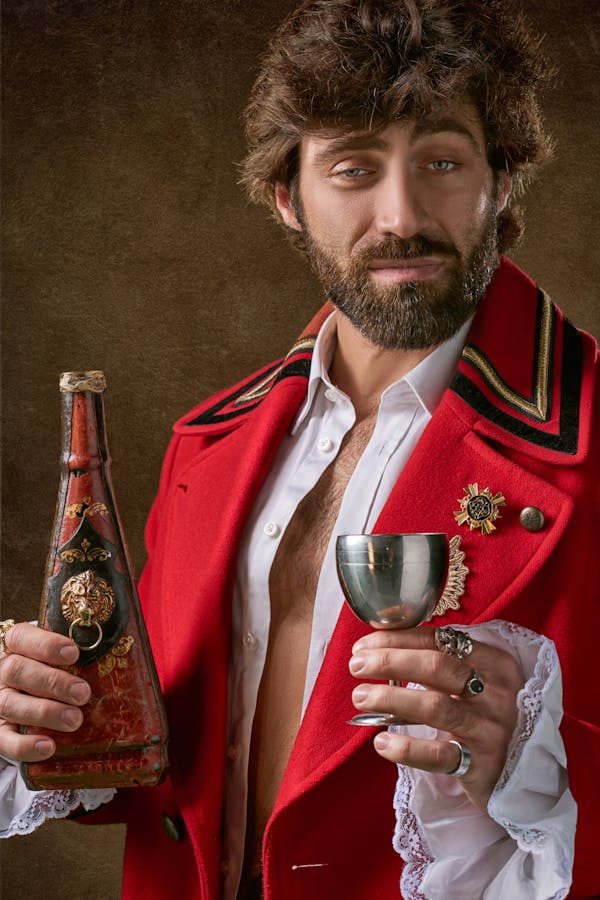 Man Holding Red And Black Bottle
