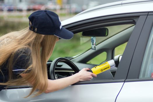 Female officer conducts breathalyzer test on driver for road safety.