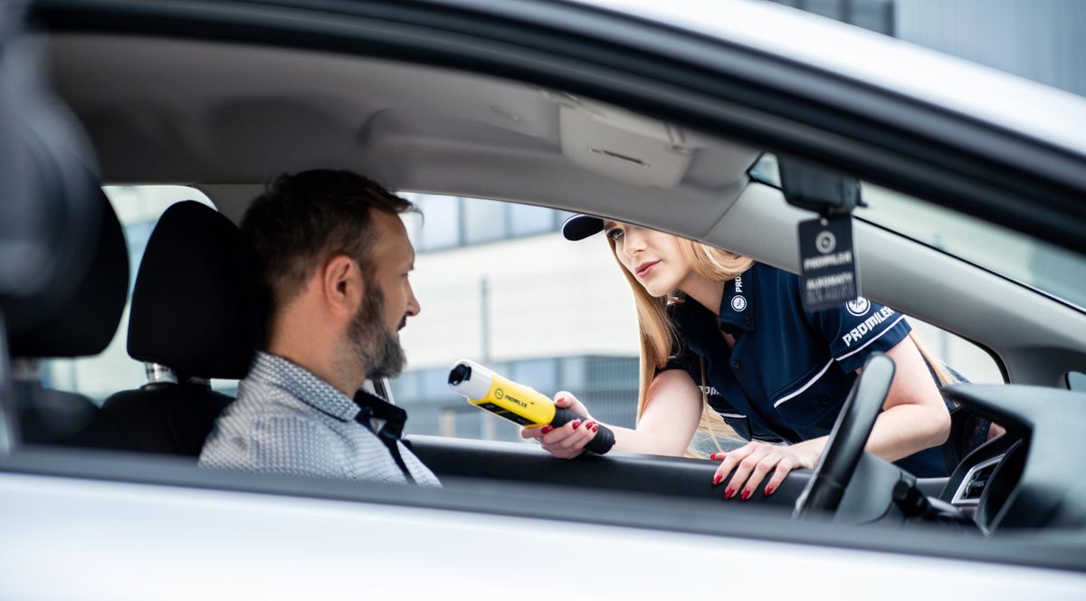 A police officer conducting a roadside breathalyzer test on a driver