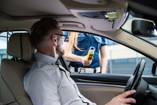 Free Officer administering a breathalyzer test to a driver during a roadside check for safety. Stock Photo